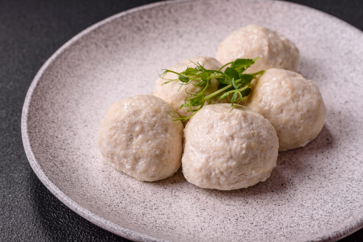 Соковиті курячі тефтелі з кус-кусом і шпинатом на пару