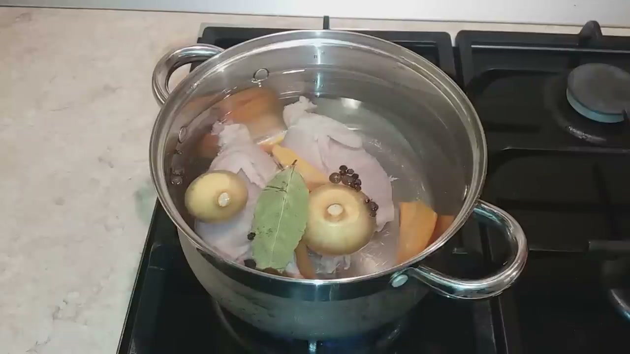 М'ясо з кістками, цибуля, морква і лавровий лист у каструлі